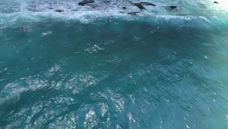 Aerial-view-of-the-waves-of-crystal-blue-water-on-shore-line-of-diamond-beach-in-Nusa-Penida,-Indonesia