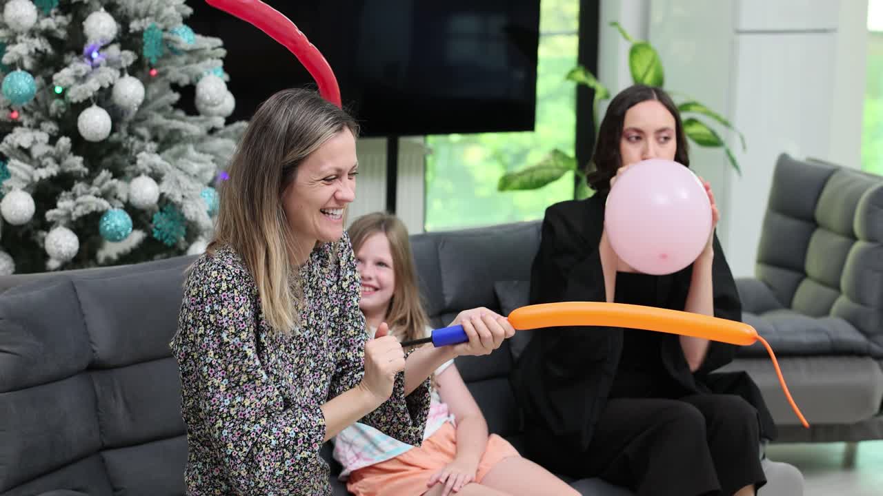 Family and friends having fun inflating balloons in a living room