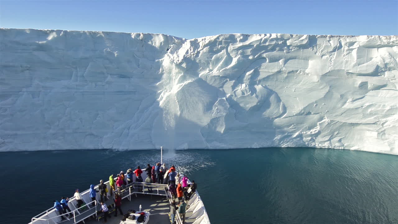 una cascada sale del casquete polar de austfonna en noruega, lo que sugiere el calentamiento global con un barco en primer plano