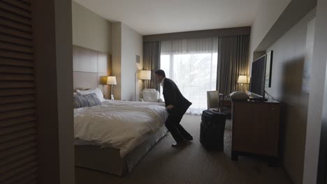 Business-Man-in-Suit-Entering-Hotel-Room---Dives-on-Bed-Exhausted