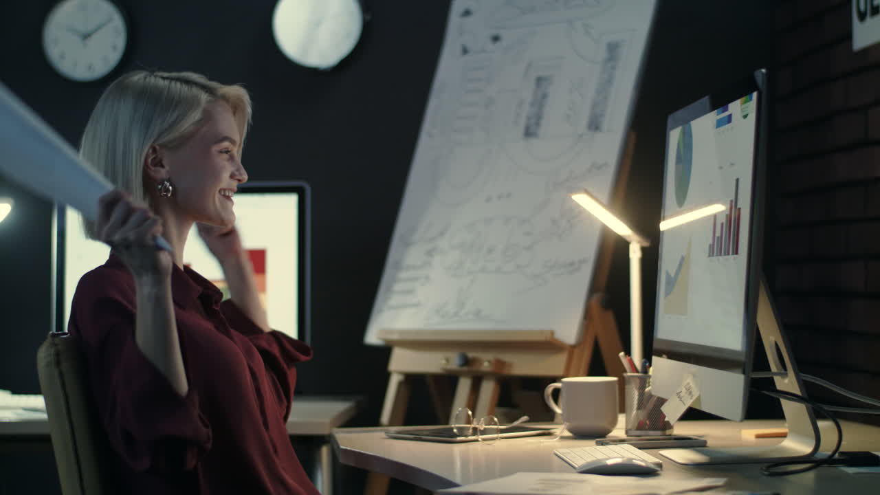 Happy business woman rejoicing good results in night office.