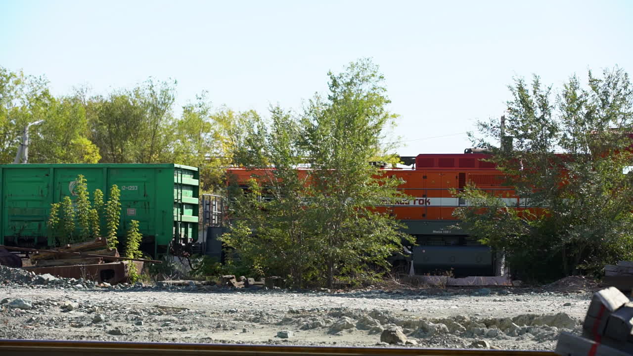 Industrial Train Yard with Orange Locomotive