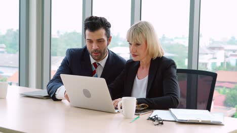 Two-business-people-talk-project-strategy-at-office