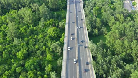 aerial view of car traffic on modern bridge over river in city in summer day