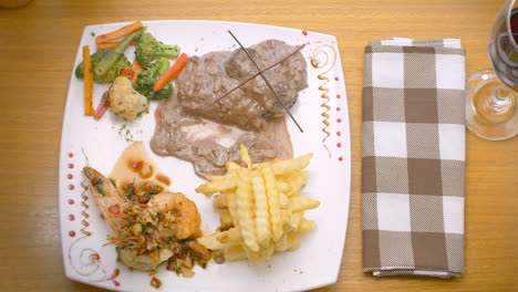 meat in sauce, prawns, french fries and steamed vegetables, mediterranean