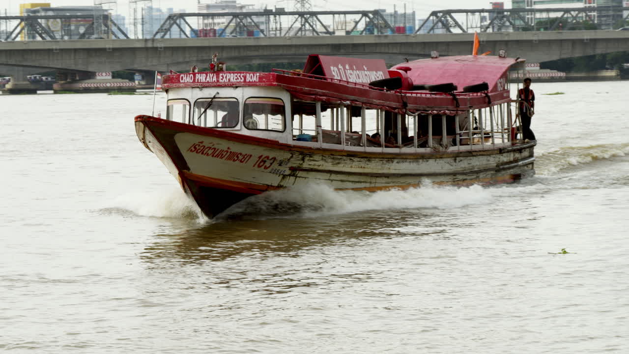 Bangkok’s Chao Phraya Express Boat Approaching the Dock for Passenger Transport, Highlighting Efficient Water Traffic and Urban Mobility by River