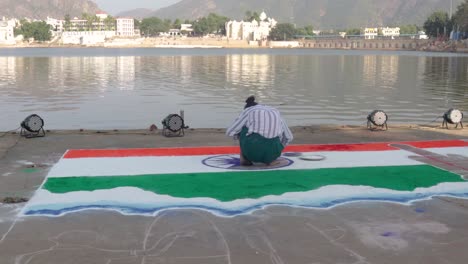 Eine-Frau-Zeichnet-Indische-Flagge-Auf-Pushkar-Ghat-Mit-Buntem-Pulver,-Rangoli-künstler