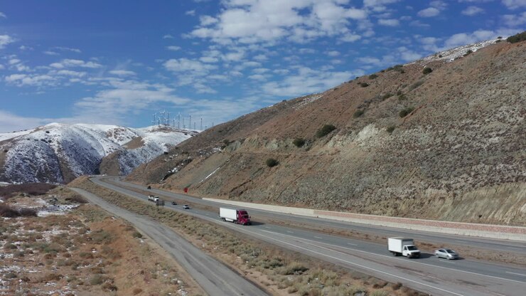 auto e camion a lungo raggio guidano sull'autostrada di montagna della california in inverno, aerea