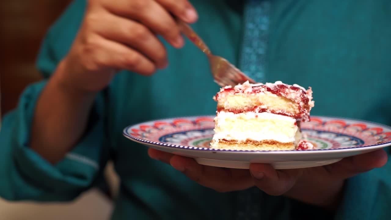 Person Eating a Slice of Delicious Layer Cake