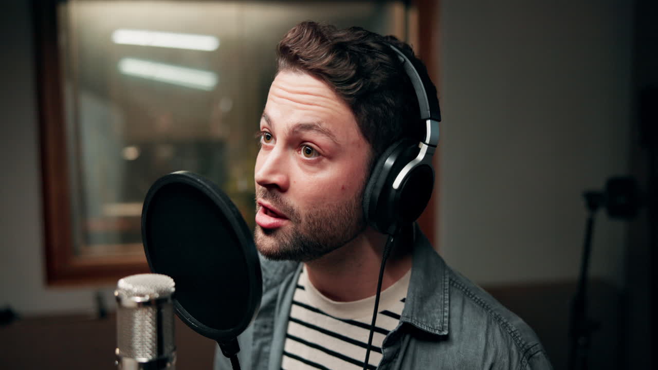 hombre cantando en el micrófono en el estudio de grabación