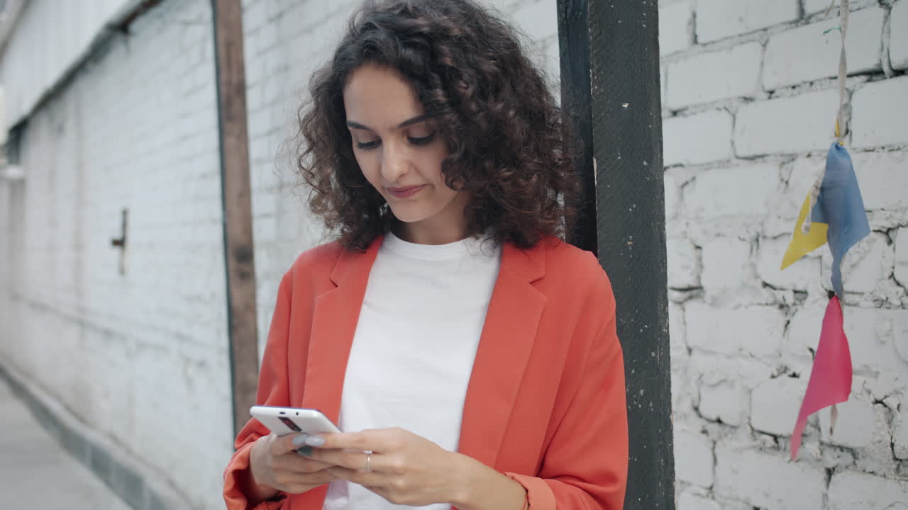 mujer usando un teléfono en una calle de la ciudad