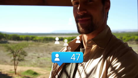 man leaning wooden beam on grassy porch, showing social media icons and blue notification bubble