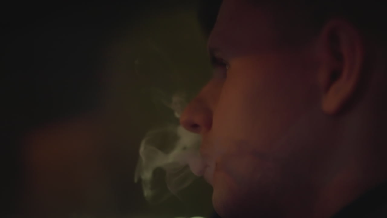 Driver smoking reflection, Thoughtful Caucasian driver exhaling smoke in dim neon environment, Interior view of reflective driver with neon highlights and drifting smoke ambiance inside vehicle