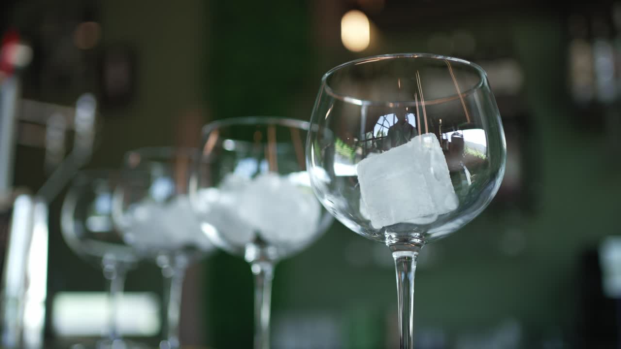Eleganti bicchieri di cristallo con ghiaccio in un accogliente bar in penombra