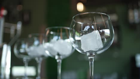elegant crystal glasses with ice in a cozy dim bar