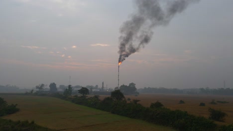 thick black smoke constantly billowing out of the chimney at gas refinery