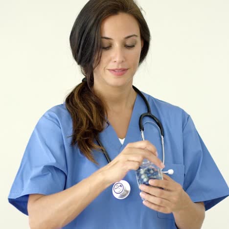 atractiva doctora sosteniendo una pastilla