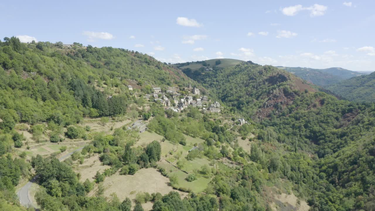 La Vinzelle, pittoresco villaggio francese di montagna nella campagna lussureggiante, vista aerea con movimento dolly ascendente a sinistra.