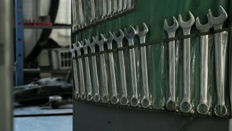 mechanic working on wrenches in a garage