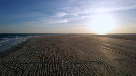 Drone-shot-of-The-Point-at-Emerald-Isle,-into-the-sun