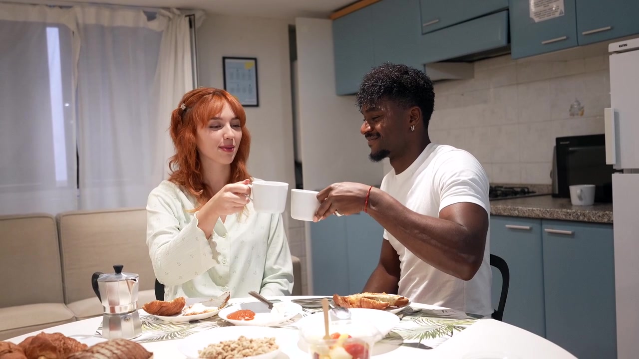 Young Couple Having Breakfast and Drinking Coffee Together at Home