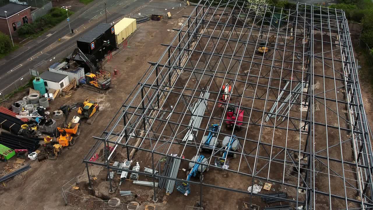 Aerial view overlooking Aldi grocery store building site foundation steel framework and construction equipment