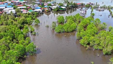 aerial clip revealing the water shrubs and hut settlements over a water locked shrimp farming area