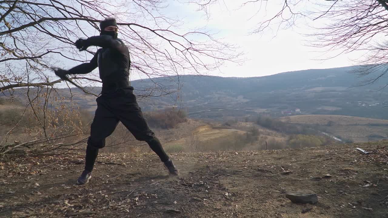 Watch a stealth ninja expertly unfold his katana while performing stunning sword tricks in an outdoor, scenic setting. Perfect for martial arts and dynamic action projects.