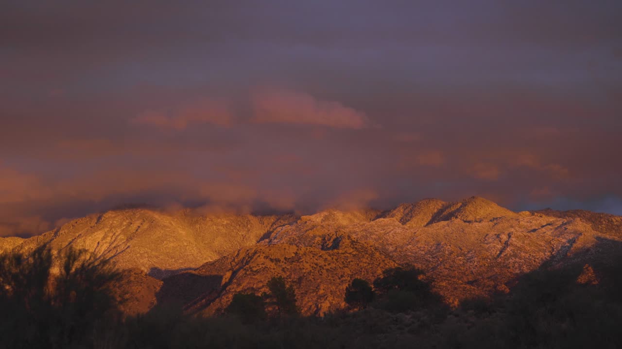 hermosa luz de puesta de sol rosa y naranja en montañas cubiertas de nieve, arizona