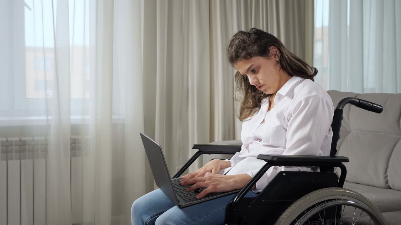 mujer discapacitada trabaja en línea en una computadora portátil sentada en silla de ruedas