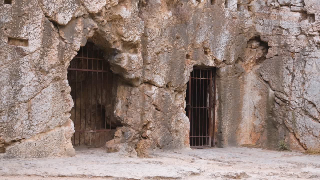 entrada a una cueva con puerta barrada en atenas, grecia