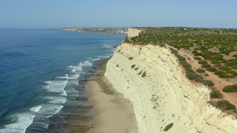 Wellen,-Die-Einen-Strand-Unter-Einer-Riesigen-Klippe-Treffen