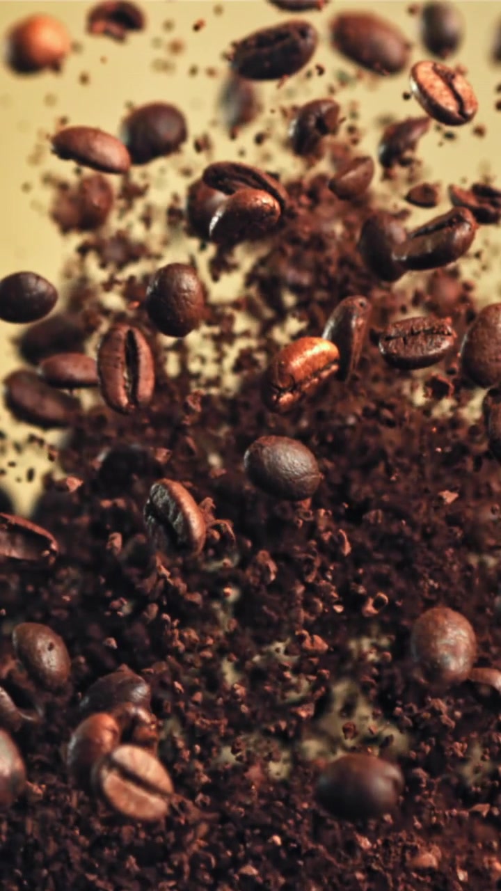 Chicchi di caffè tostati e macinato che salgono al rallentatore