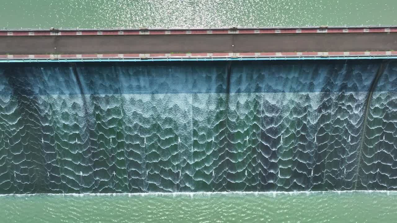 Aerial top down shot of splashing water of dam in Taiwan during sunny day
