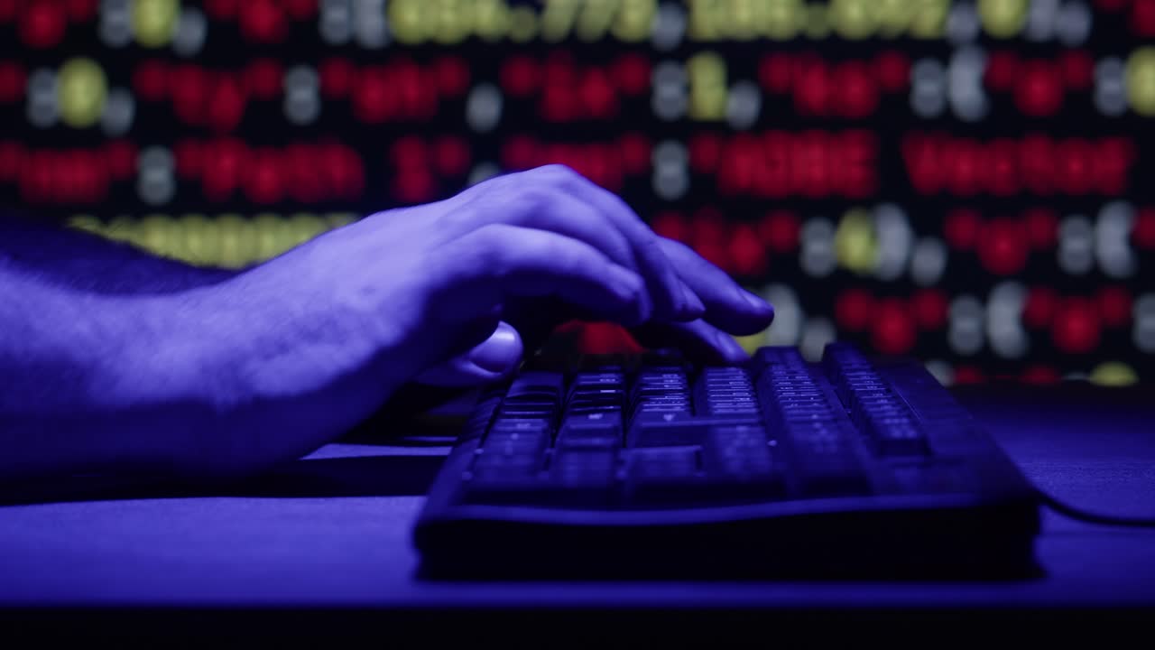 Person Typing on a Keyboard in Front of a Blurry Binary Code Background