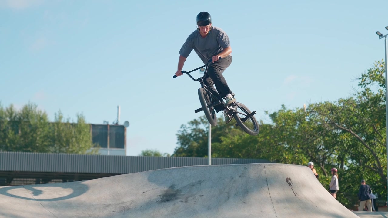 Giovane in BMX che salta su una rampa in uno skatepark