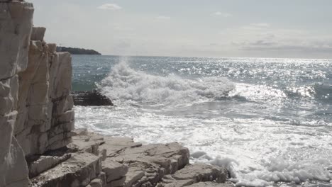 giant waves crashing agaist huge stony wall during sunlight and water reflection in nature