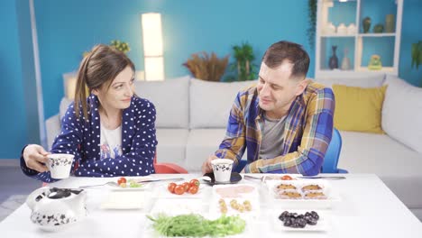 Cheerful-and-funny-married-couple-are-having-breakfast-at-home.