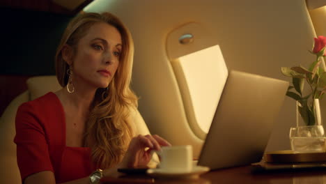 Closeup-rich-woman-working-laptop-computer.-Relaxed-lady-take-break-enjoy-coffee