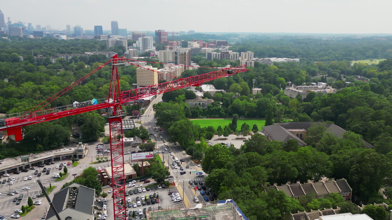vista aérea de un avión no tripulado volando alrededor de la grúa de torre alta roja en el sitio de construcción