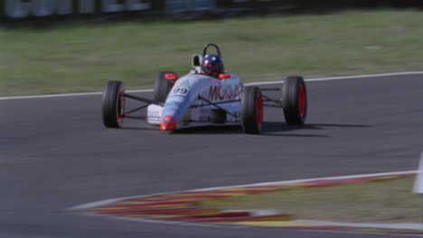 racing cars round a bend in a racetrack