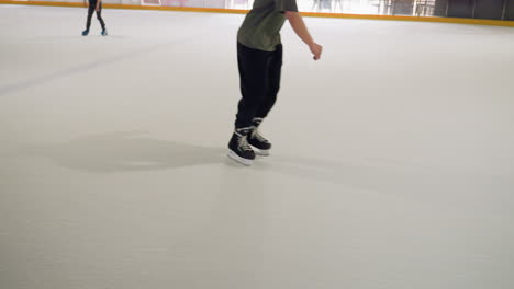 a boy wearing black trousers is seen skiing on a pristine white surface, with other people skiing in the background. highlighting the active environment and motion