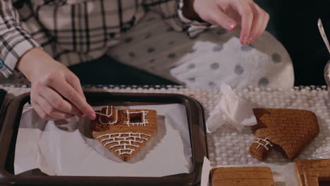 child decorating gingerbread house