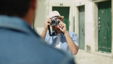 front view of smiling man taking photo of boyfriend on camera