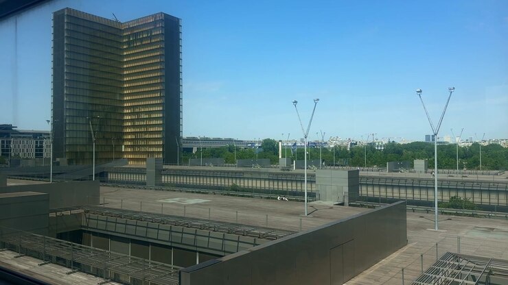 Torre de vidro e esplanada de madeira da Bibliothèque nationale de France François Mitterrand em Paris, vista através de uma janela em um dia ensolarado