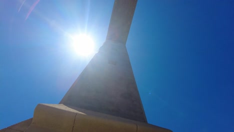 gran cruz con fondo de cielo azul de verano en el monte filerimos, rhode island, grecia - ángulo bajo, tiro en órbita