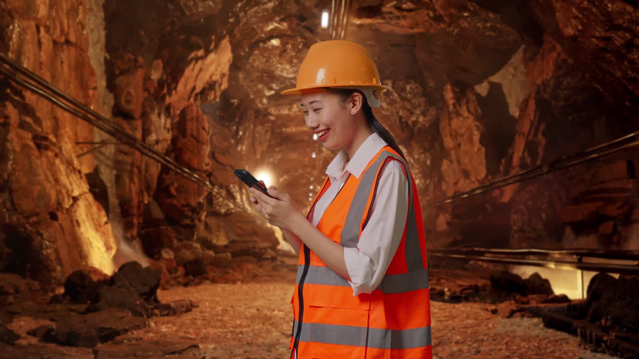 Female Engineer using smartphone in a mine tunnel