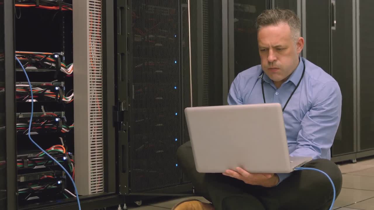 Technician using laptop to analyse server