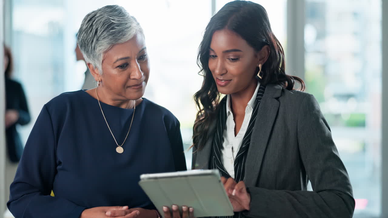 Donne d'affari che collaborano su un tablet in ufficio