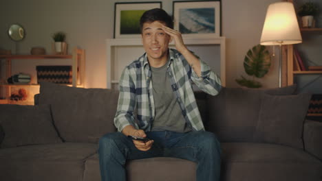man relaxing on couch watching tv